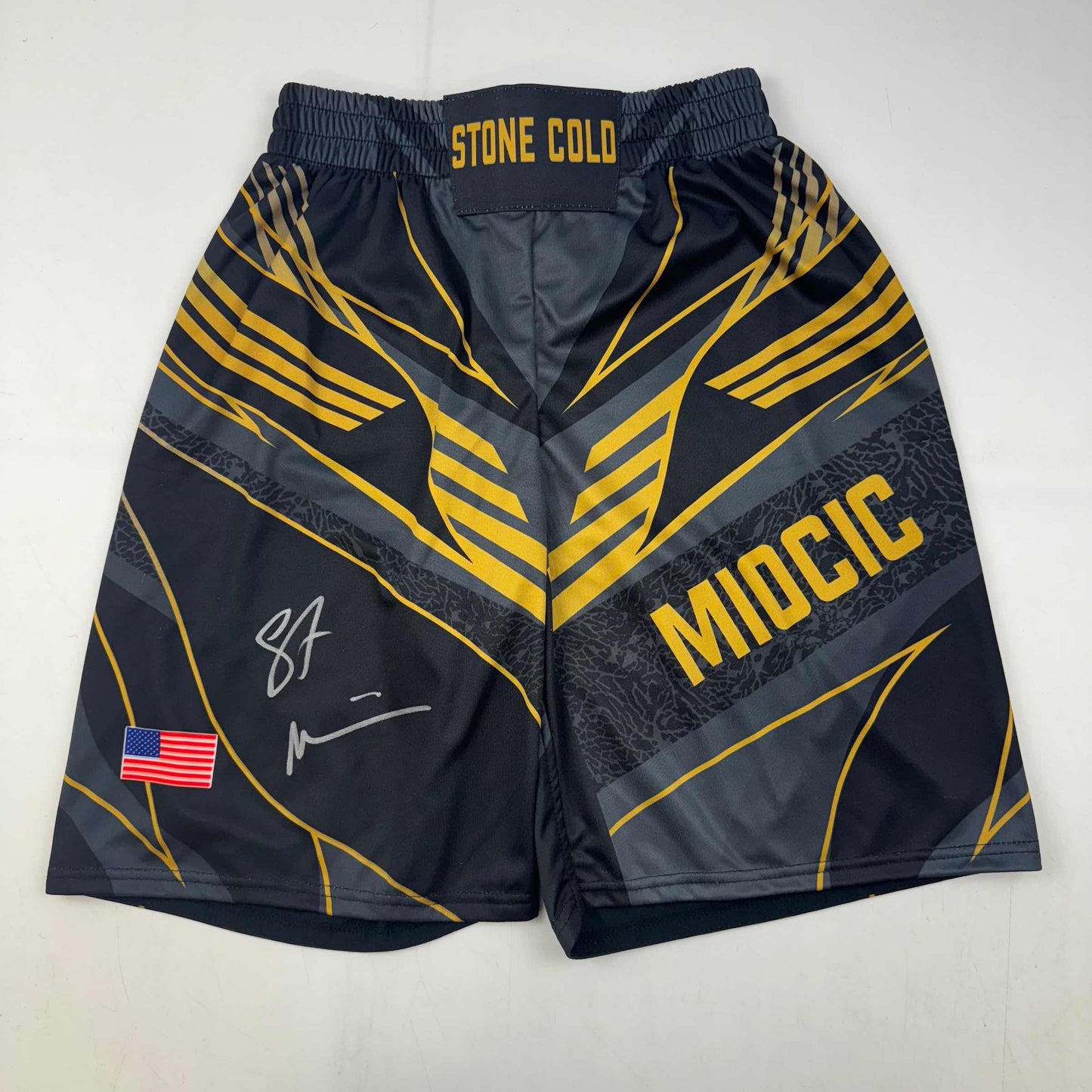 Autographed/Signed Stipe Miocic Black and Gold UFC MMA Trunks Shorts Ultimate Fighting Beckett BAS COA